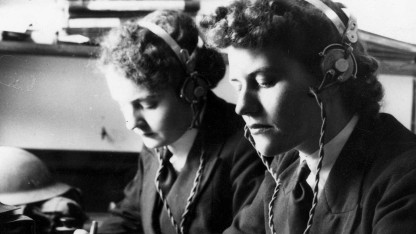 Image of two women using the encoding machine. 